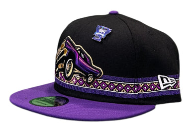 Black cap with purple and gold band on a green and black surface